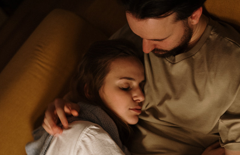couple laying side-by-side on a couch