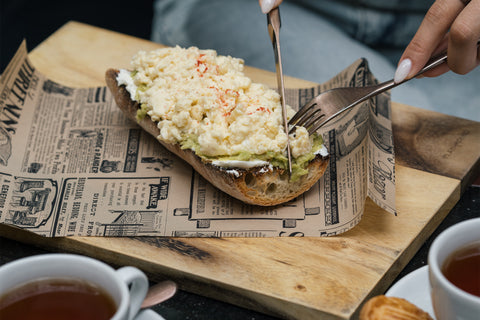 Woman cutting into an open face sandwich