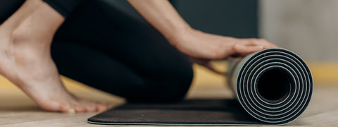 Woman rolling up yoga mat